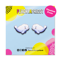 Peachy Apricot whale-shaped earrings on a colorful background with brand name and social media handles.