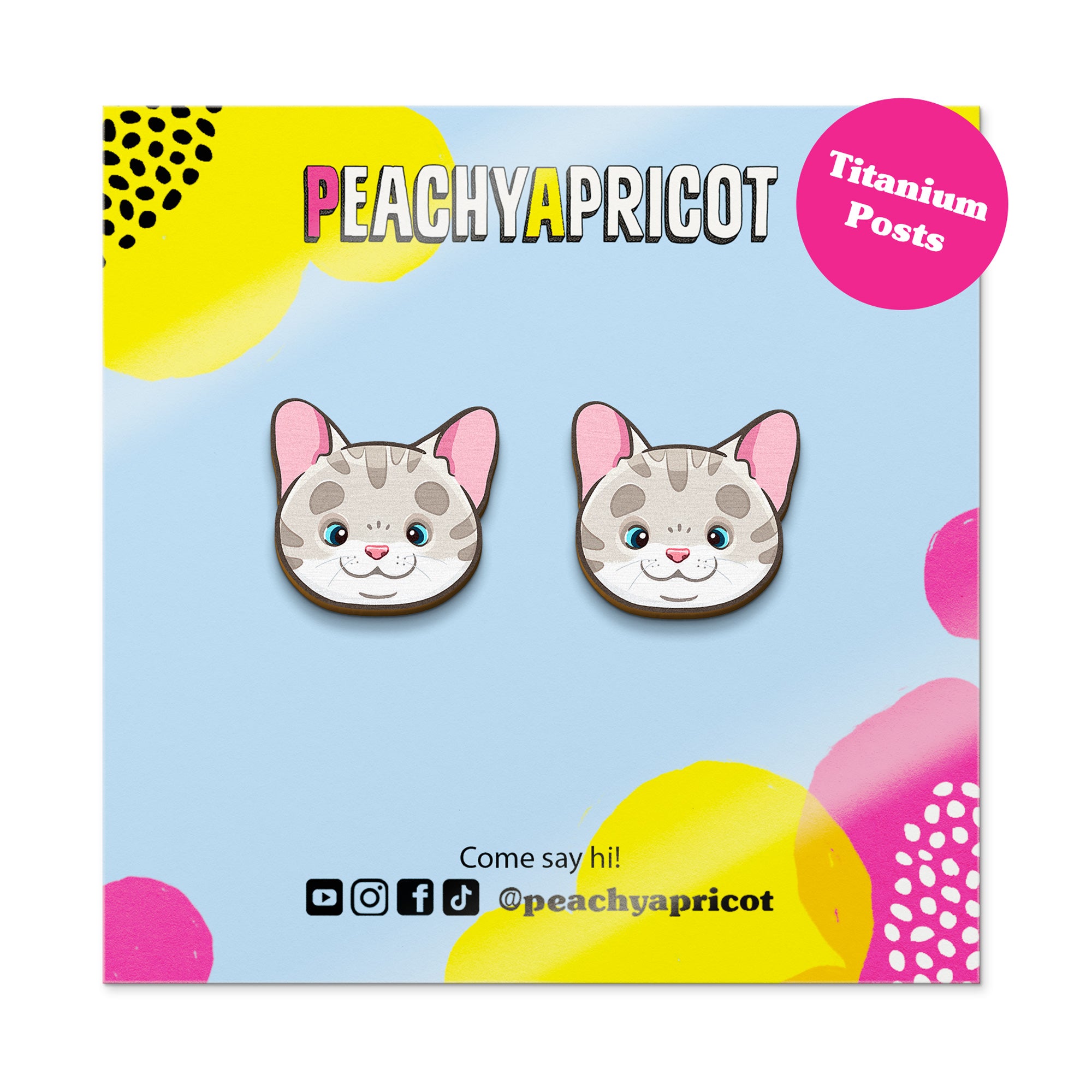 Cat-shaped earrings on a colorful card with 'Peachy Apricot' branding.