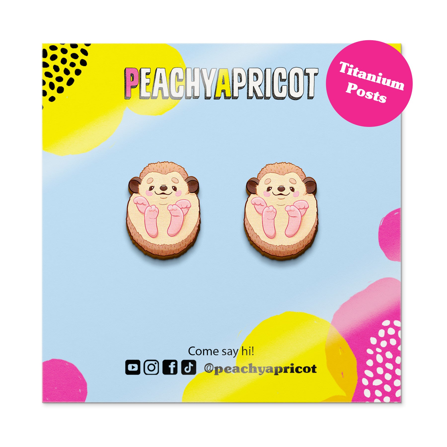 Earrings with sloth design on a colorful 'Peachy Apricot' branded card.