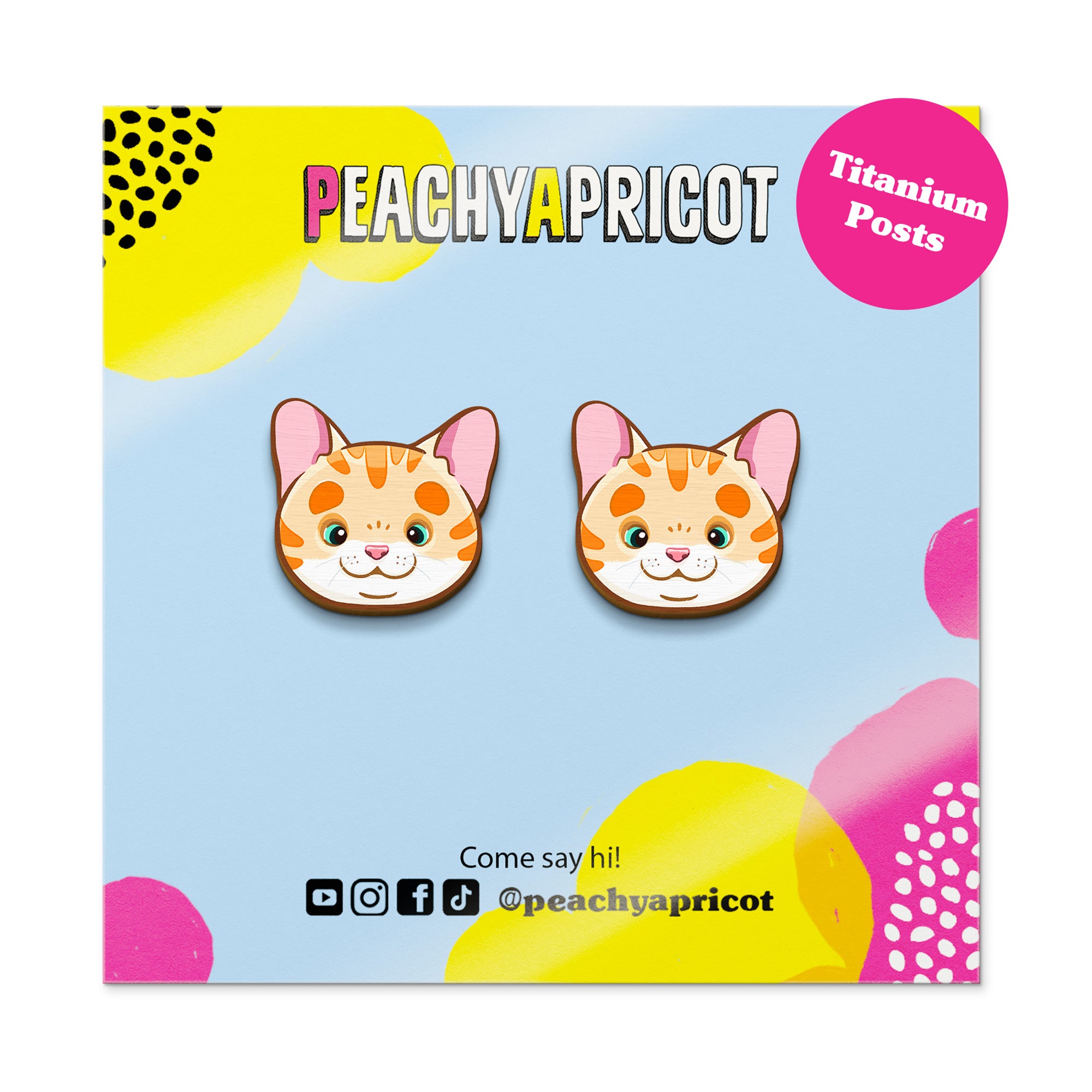 Cat-shaped earrings on a colorful card with 'Peachy Apricot' branding.