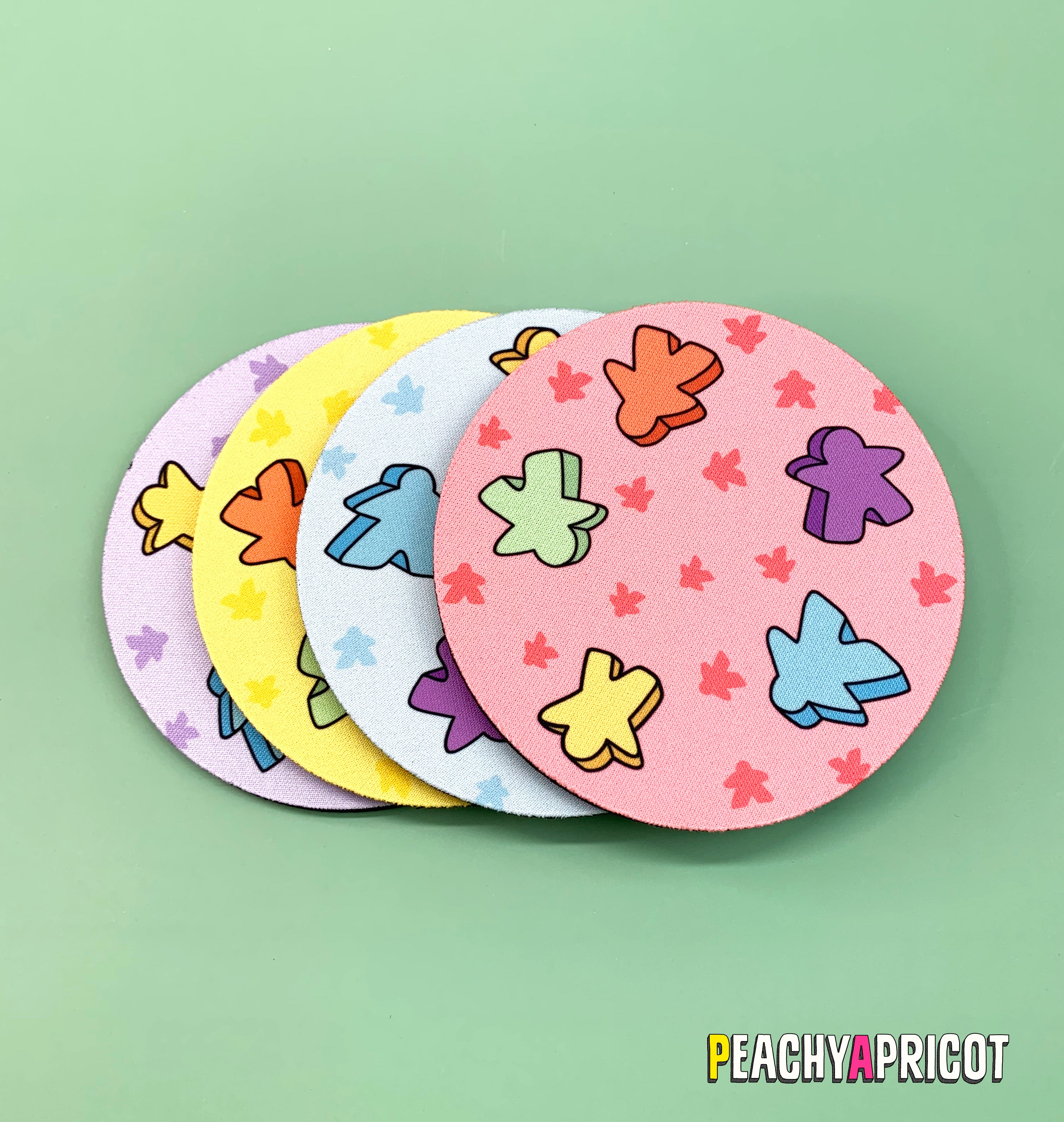 set of 4 board game inspired coasters with meeples printed all over them in different colors